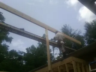 Carpenter setting a ridge beam over a new addition frame — Ice Dam Removal by Roofing Brothers in Cardiff By The Sea