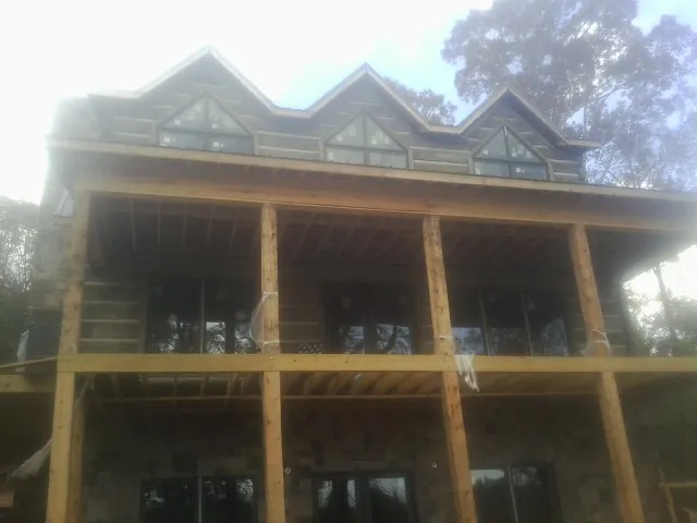 Dormers and porch framing on a large log home under construction — Roof Coating work by our crew in Cardiff By The Sea