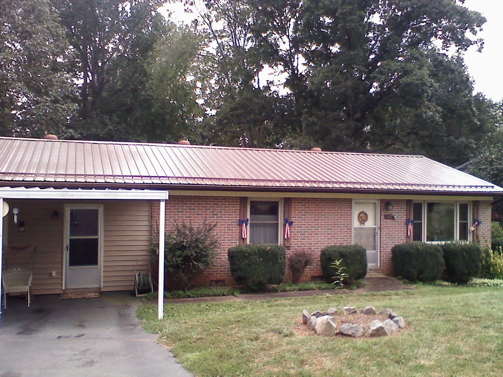 Bronze metal roof and carport on a brick ranch home — Roof Repair work by our crew in Cardiff By The Sea
